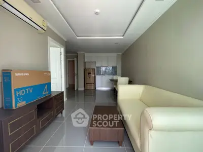 Modern living room with sleek furniture and boxed appliances in a bright, open layout.