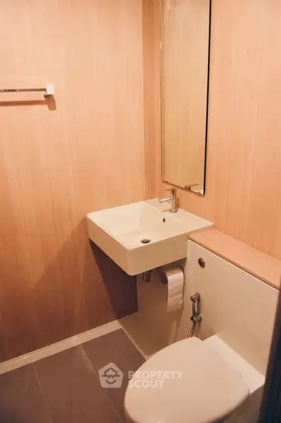 Modern compact bathroom with sleek fixtures and wooden paneling