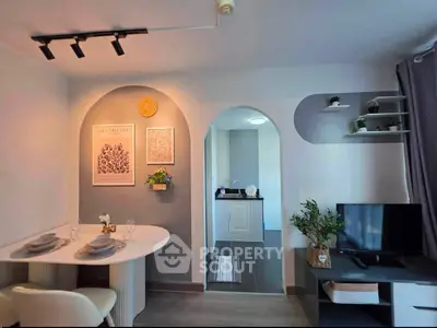 Stylish modern living room with dining area and open kitchen, featuring elegant decor and cozy ambiance.