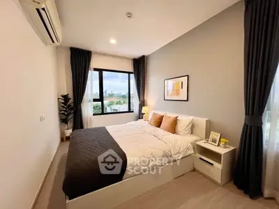 Modern bedroom with large window and stylish decor in a cozy apartment.