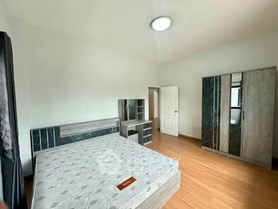 Spacious bedroom with modern furniture and wooden flooring, perfect for a cozy living experience.
