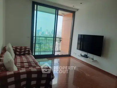 Modern living room with city view and balcony access, featuring a wall-mounted TV and cozy sofa.