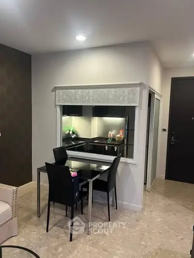 Modern apartment interior with compact dining area and open kitchen layout.