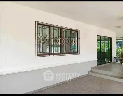 Spacious covered patio with modern sliding glass doors and security window grills