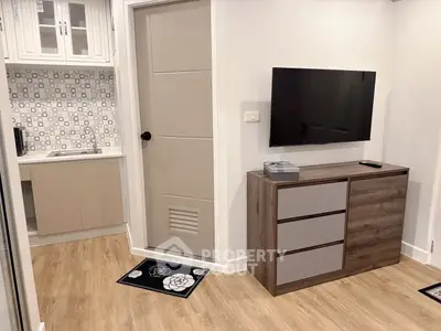 Modern living room with sleek TV setup and stylish cabinetry in a cozy apartment.
