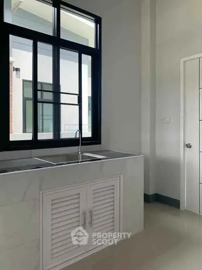 Modern kitchen with sleek design and large window for natural light