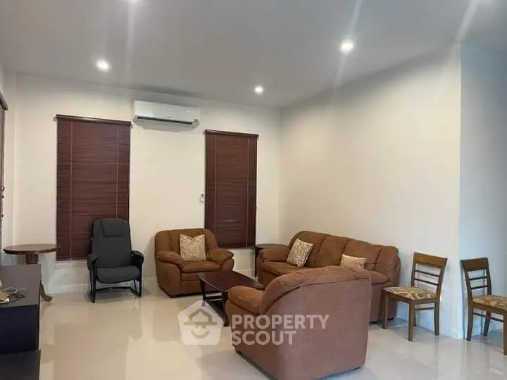 Spacious living room with cozy brown sofas and modern lighting, perfect for relaxation and entertainment.