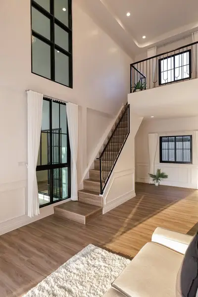 Spacious modern living room with high ceilings and elegant staircase