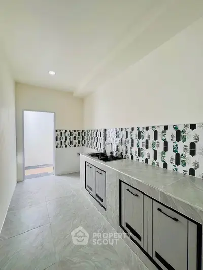 Modern kitchen with sleek cabinetry and stylish backsplash in a bright, minimalist design.