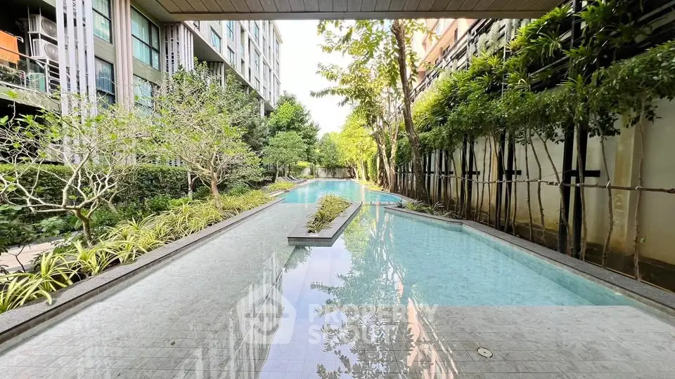 Luxurious residential building with serene outdoor pool and lush greenery, perfect for relaxation and leisure.