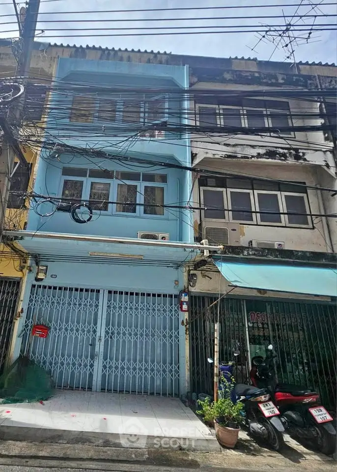 Charming urban townhouse with gated entrance and vibrant facade, ideal for city living.
