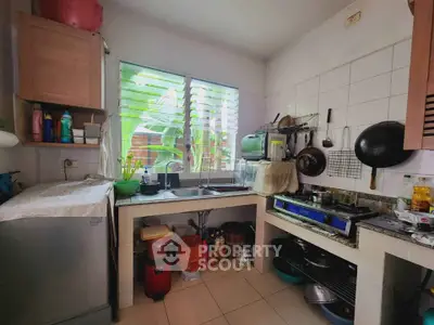 Cozy kitchen with gas stove and ample natural light, perfect for culinary enthusiasts.