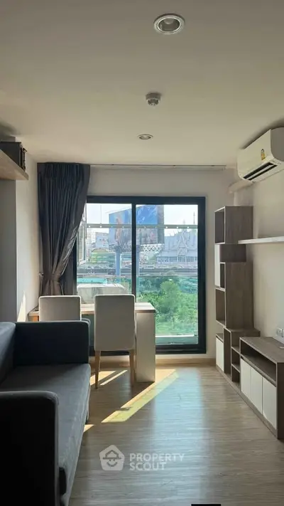 Modern living room with city view, featuring sleek furniture and large window for natural light.
