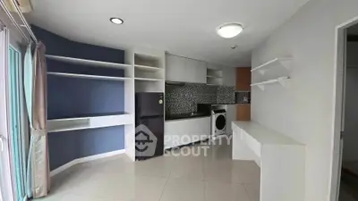 Modern kitchen with sleek cabinetry, washing machine, and stylish shelving in a compact layout.