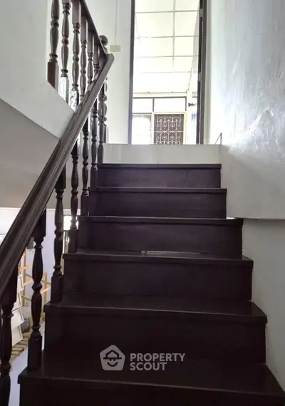 Charming wooden staircase leading to upper floor with natural light