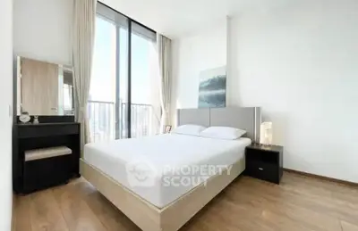 Modern bedroom with large windows and minimalist decor in a high-rise apartment.