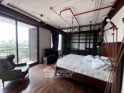 Spacious bedroom with balcony and city view, featuring modern industrial design.