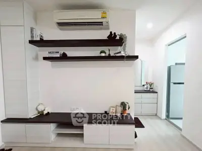 Modern living room with sleek shelves and air conditioning, adjacent to a stylish kitchen area.