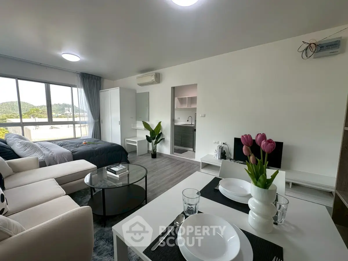 Modern open-plan living space with stylish decor and large windows offering scenic views.