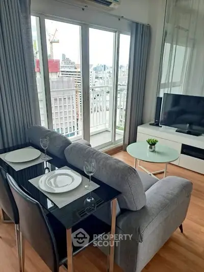 Modern living room with city view, featuring sleek furniture and large windows for natural light.