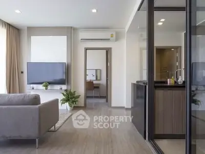 Modern living room with sleek design and open layout, featuring a cozy sofa and large TV.