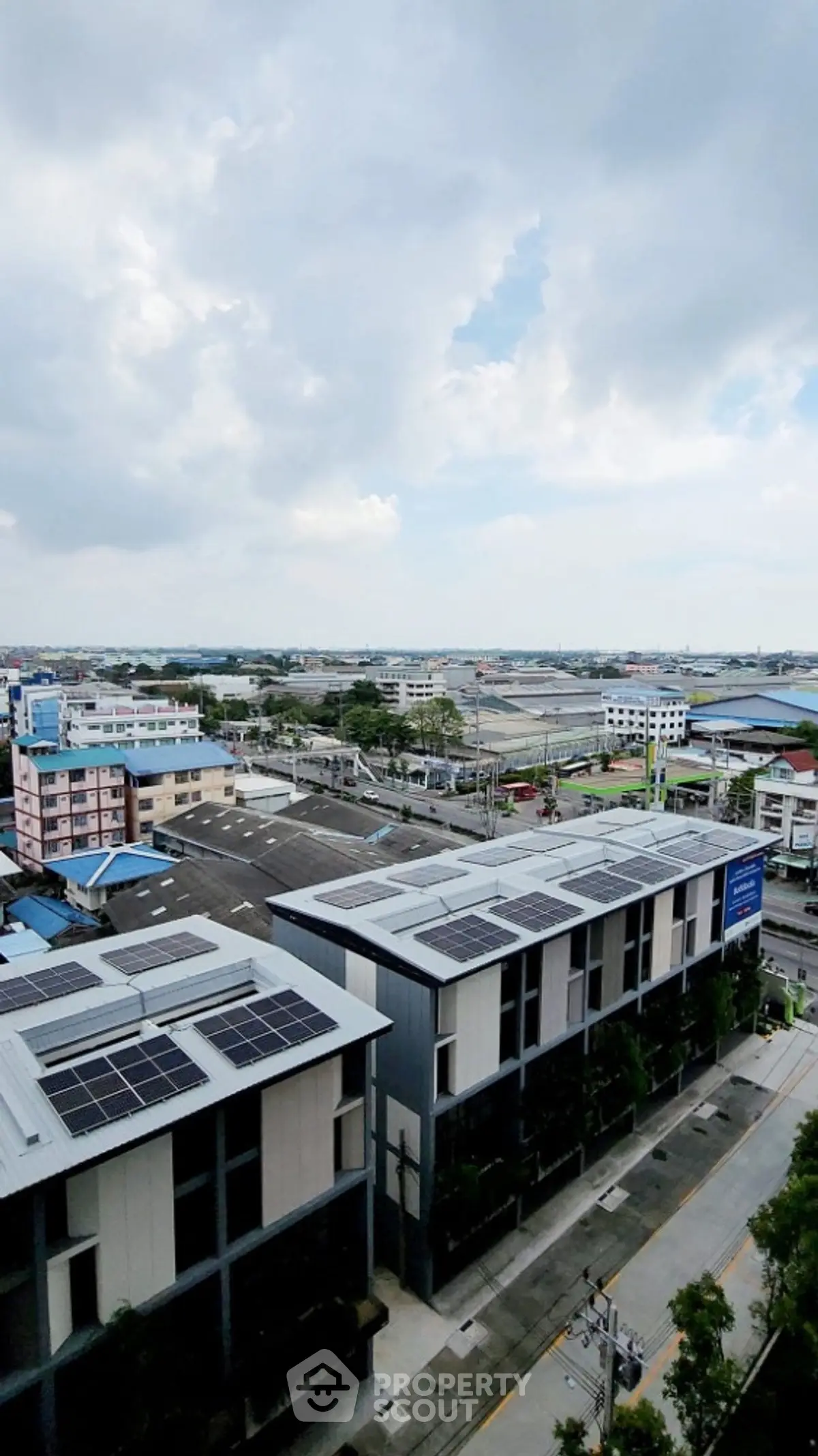Stunning aerial view of modern buildings with solar panels and expansive cityscape.