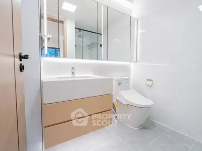 Modern bathroom with sleek fixtures and elegant design, featuring a spacious vanity and contemporary toilet.
