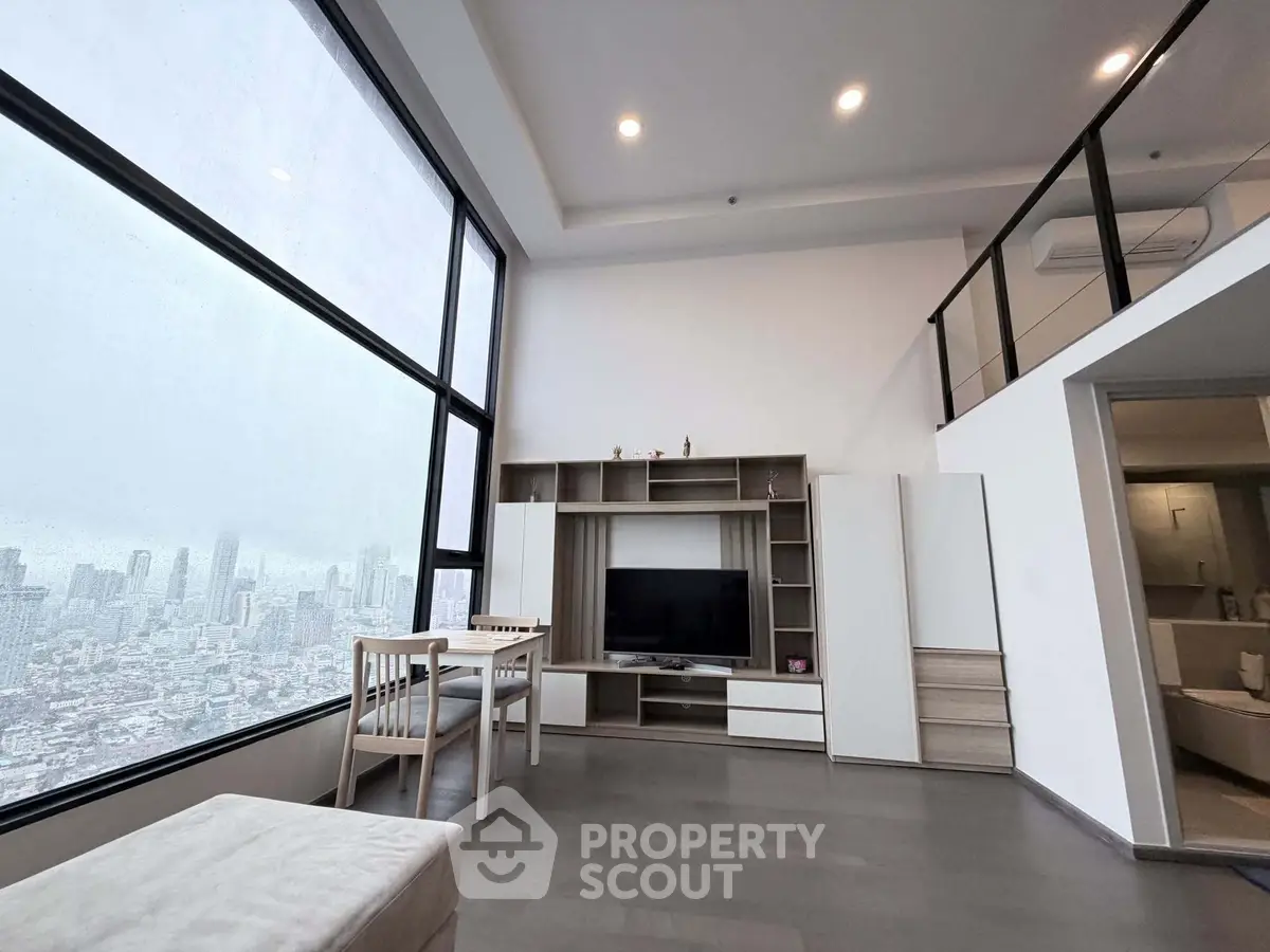 Modern living room with large window offering stunning city view, sleek furniture, and high ceiling.
