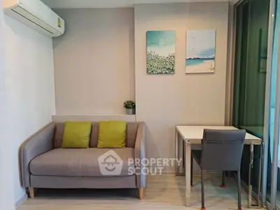 Cozy living room with modern sofa and small dining table, perfect for urban living.