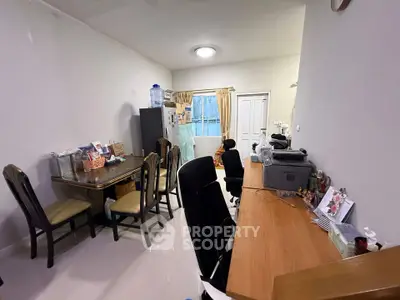 Spacious multifunctional room with dining and office areas, featuring modern furniture and ample natural light.