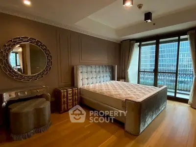 Luxurious bedroom with elegant decor and city view balcony.