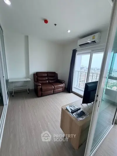 Modern living room with city view, featuring sleek furniture and large windows for natural light.