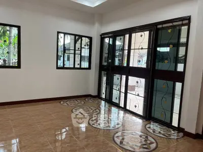 Spacious living room with decorative tiled floor and large windows