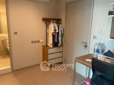 Cozy bedroom with wooden flooring, compact wardrobe, and study desk, ideal for modern living.
