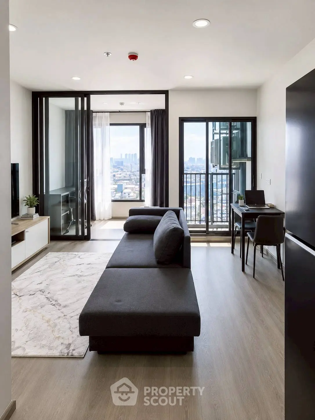 Modern living room with sleek furniture and city view from balcony, perfect for urban living.