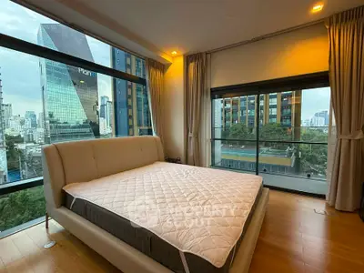 Luxurious bedroom with stunning city view and floor-to-ceiling windows in modern apartment.