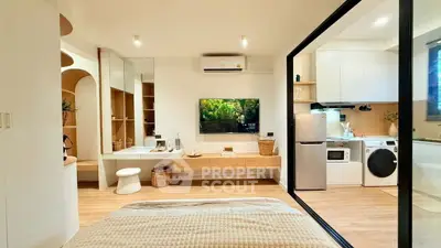 Modern studio apartment with open layout, featuring a cozy bedroom, stylish kitchen, and sleek appliances.