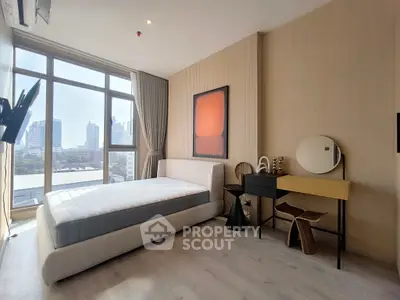Modern bedroom with large window and city view, featuring stylish decor and natural light.