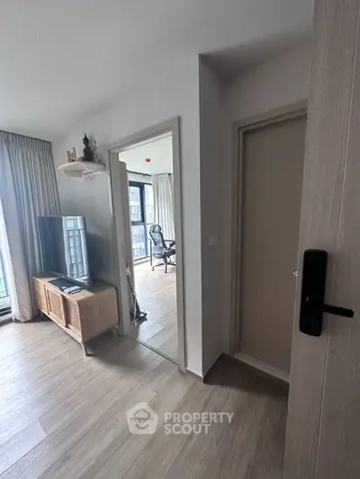 Modern apartment interior with stylish living room and study area, featuring sleek flooring and contemporary decor.