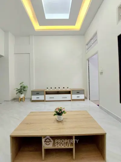 Modern minimalist living room with sleek wooden furniture and elegant ceiling lighting