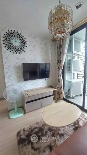 Stylish living room with modern decor, wall-mounted TV, and elegant chandelier.