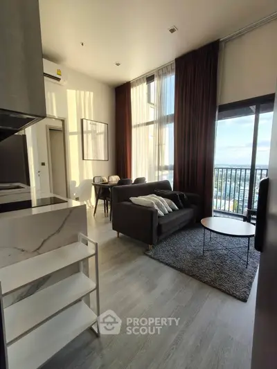 Modern living room with high ceilings and large windows offering stunning views.