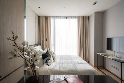 Modern bedroom with elegant decor and large window offering natural light