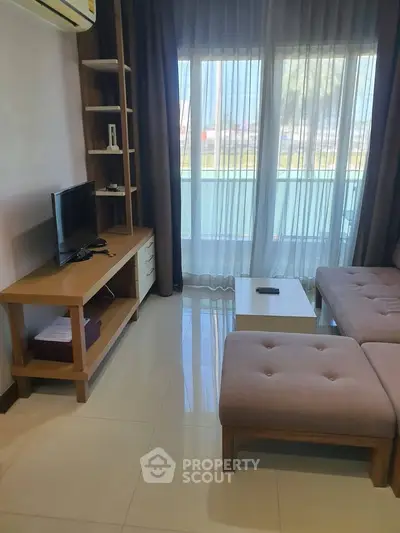 Modern living room with stylish furniture and large window offering natural light and scenic view.