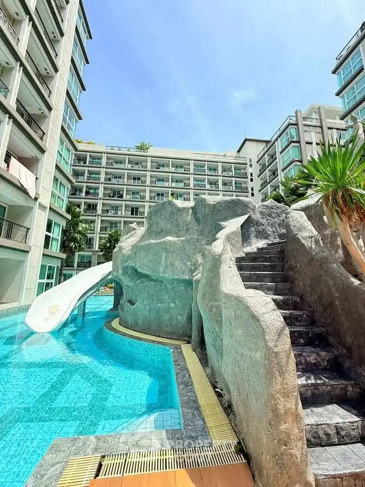 Luxurious condominium with stunning pool and slide, perfect for relaxation and leisure in a modern urban setting.