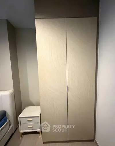 Modern bedroom with sleek wardrobe and stylish nightstand, perfect for contemporary living.