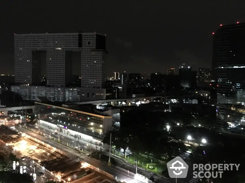 Stunning night cityscape view with illuminated modern buildings and bustling streets.