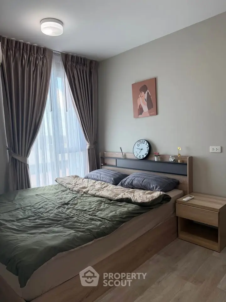 Cozy bedroom with modern decor and large window for natural light.
