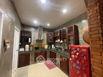 Charming rustic kitchen with red fridge and modern appliances, perfect for culinary enthusiasts.