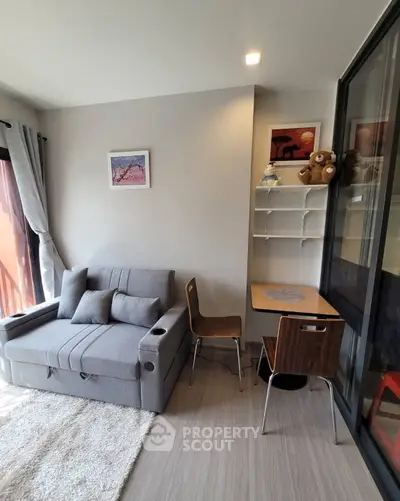Cozy living room with modern gray sofa and compact study area, perfect for urban living.